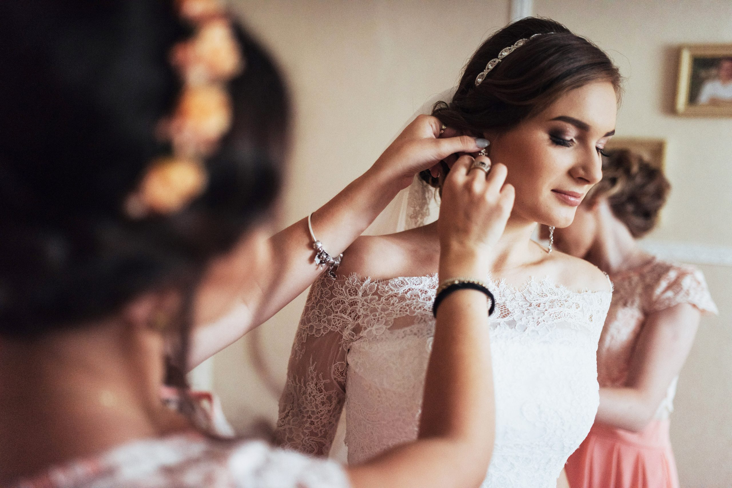 Wedding day. Beautiful bride trying on earrings